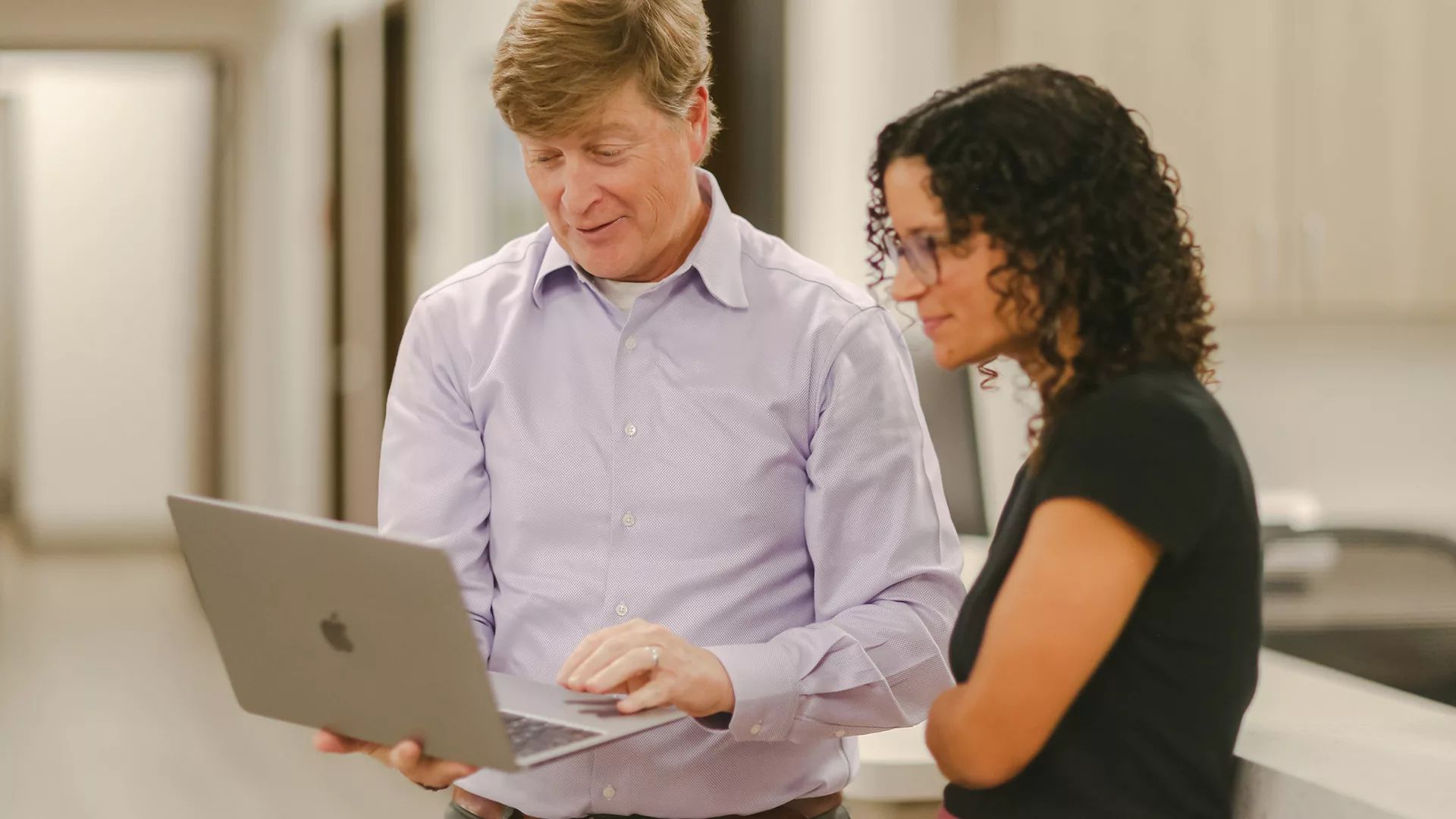 Physician collaboration and second opinion consultation A doctor consults with a colleague, reviewing patient information on a laptop to provide a second opinion.